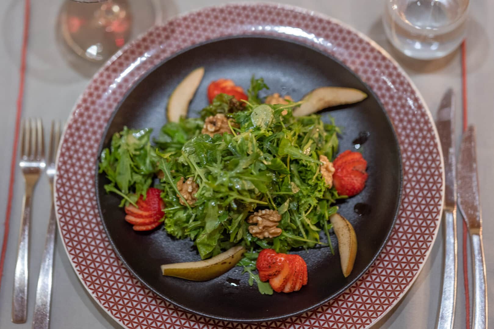 Close-up of a crisp salad dish at Euphoria Retreat, made of arugula, strawberries, pears and walnuts.