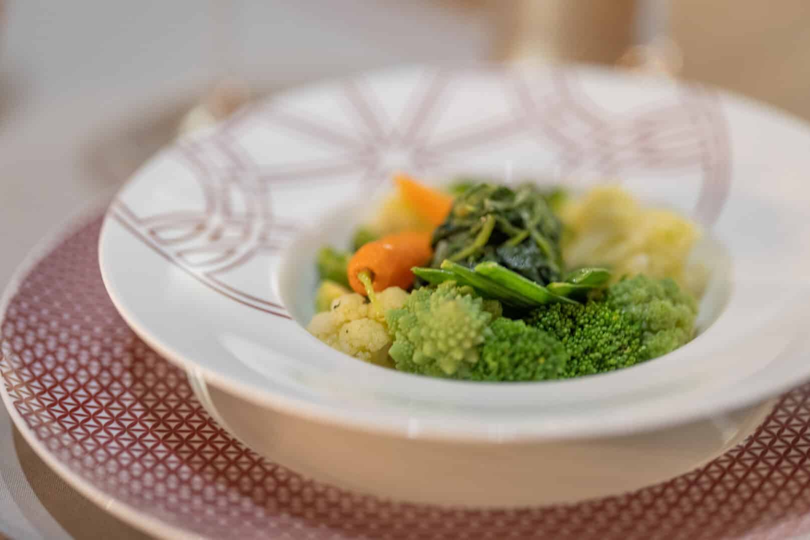 Close-up of freshly steamed vegetables, broccoli, cauliflower, greens and carrots at Euphoria Retreat.